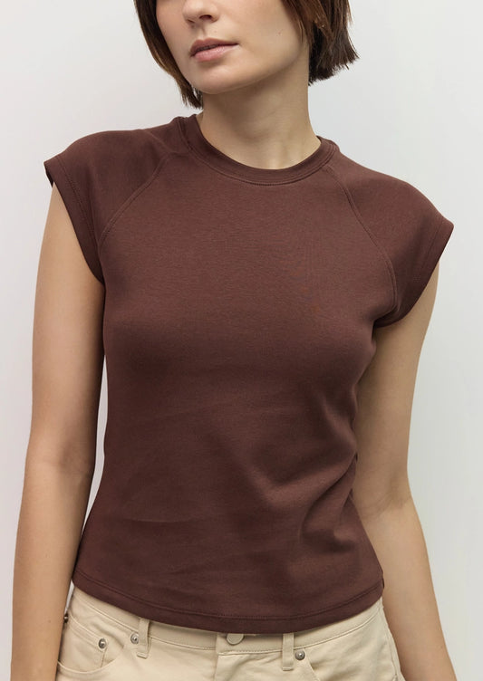 A woman wearing a raglan muscle tee in chocolate brown.