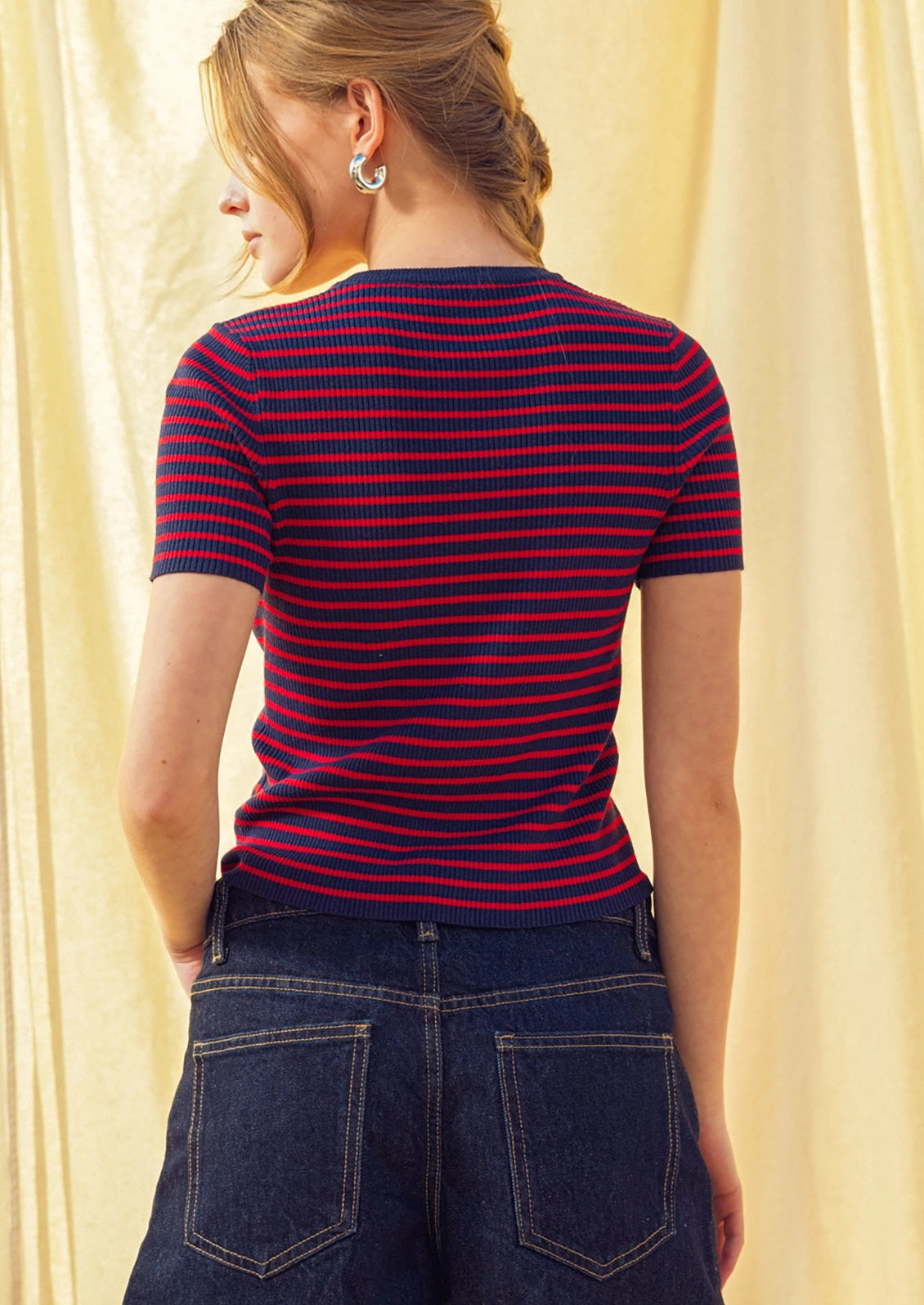 A woman wearing a short sleeve t-shirt in red and navy stripes.
