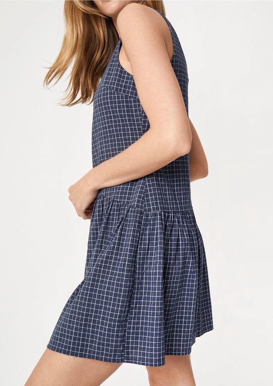A person wearing a navy mini dress with white check pattern.