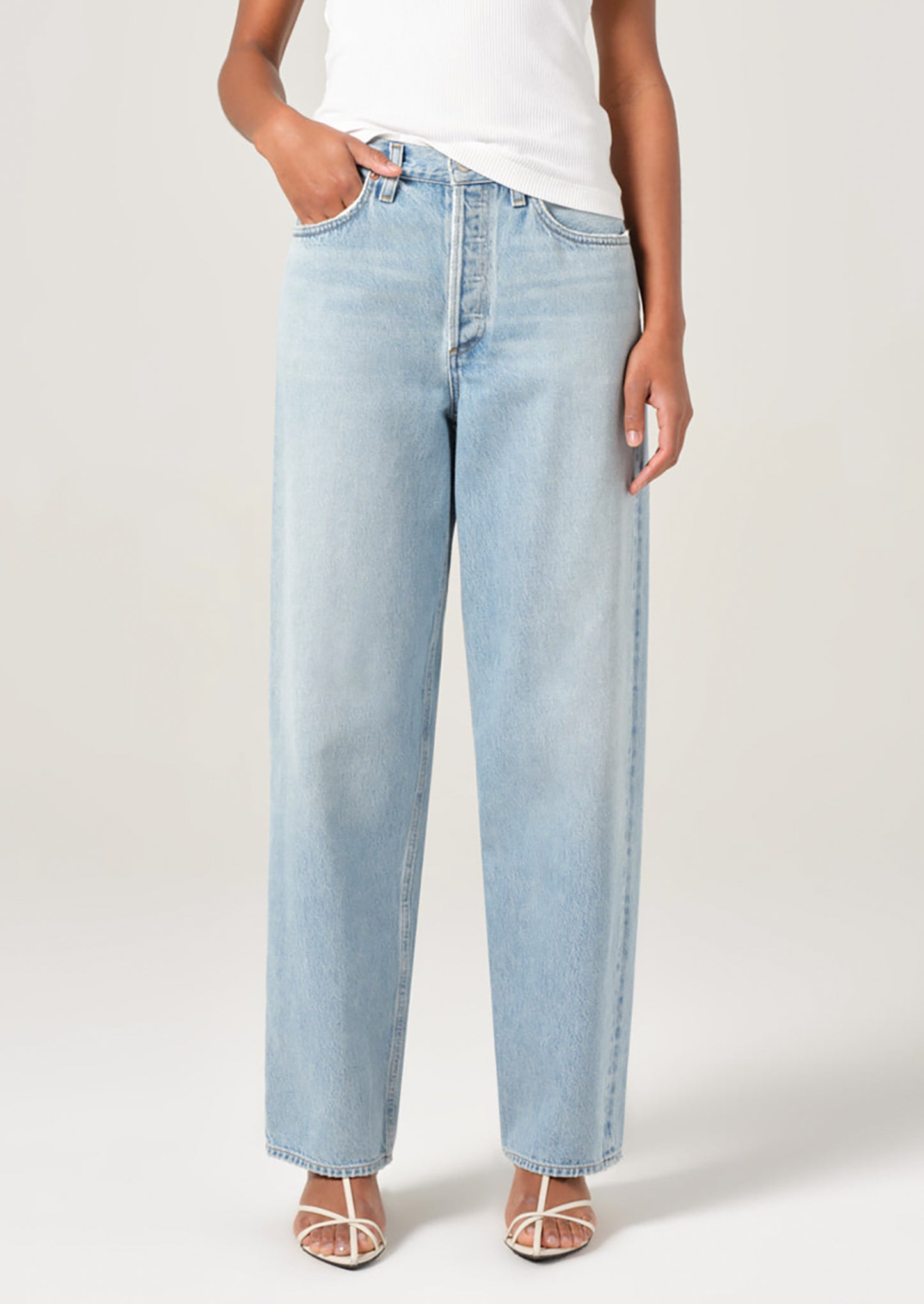 A person wearing a pair of light wash denim jeans with slightly tapered ankle.