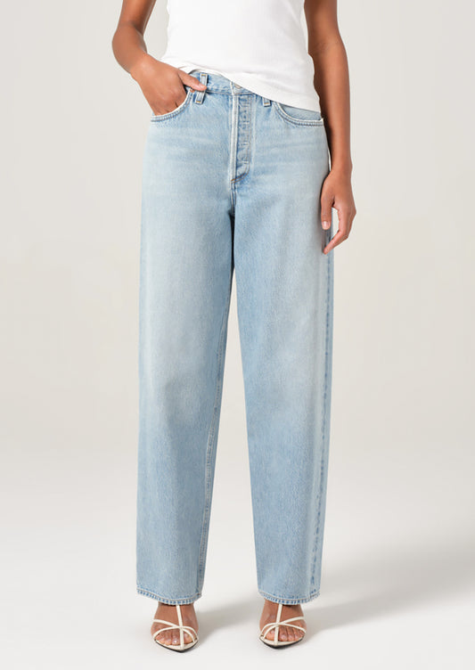 A person wearing a pair of light wash denim jeans with slightly tapered ankle.