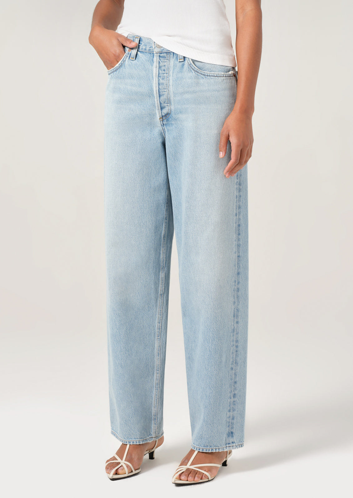 A person wearing a pair of light wash denim jeans with slightly tapered ankle.