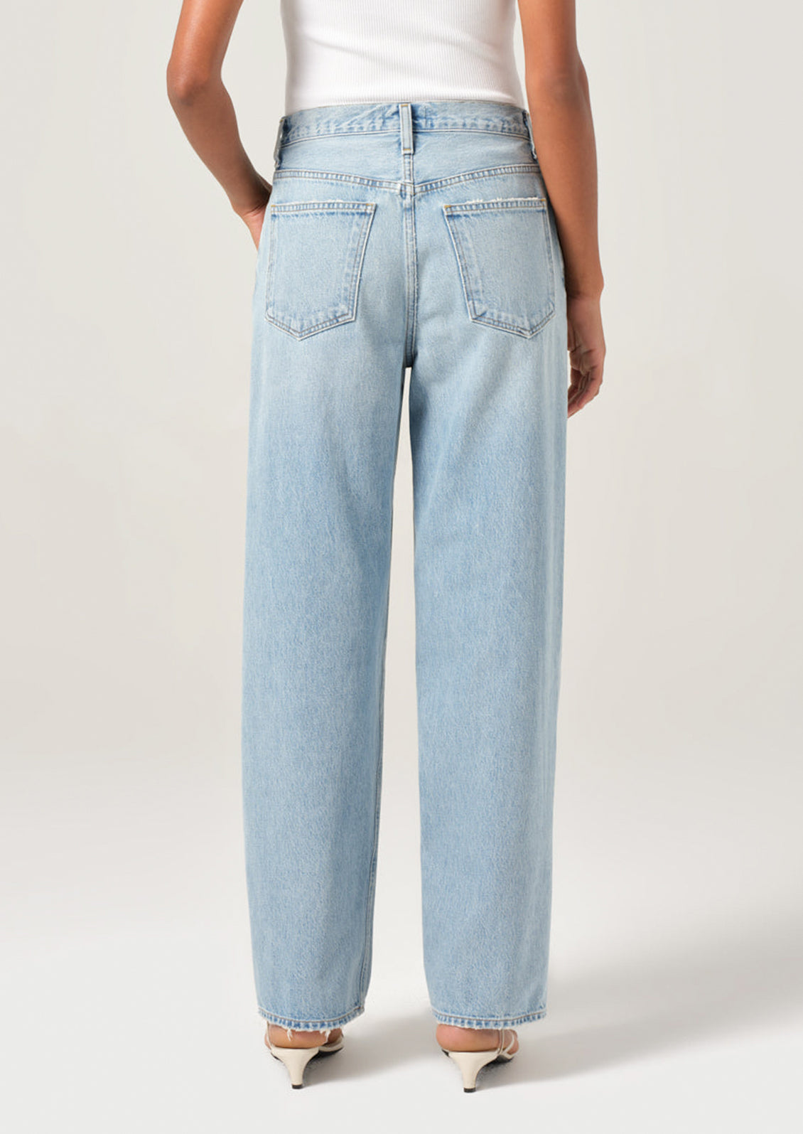 A person wearing a pair of light wash denim jeans with slightly tapered ankle.