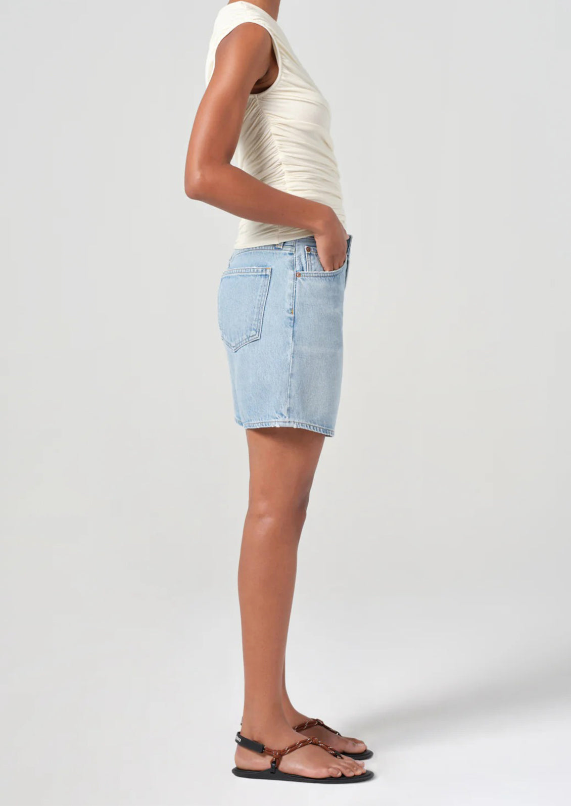 A person wearing a pair of relaxed denim shorts in light wash.