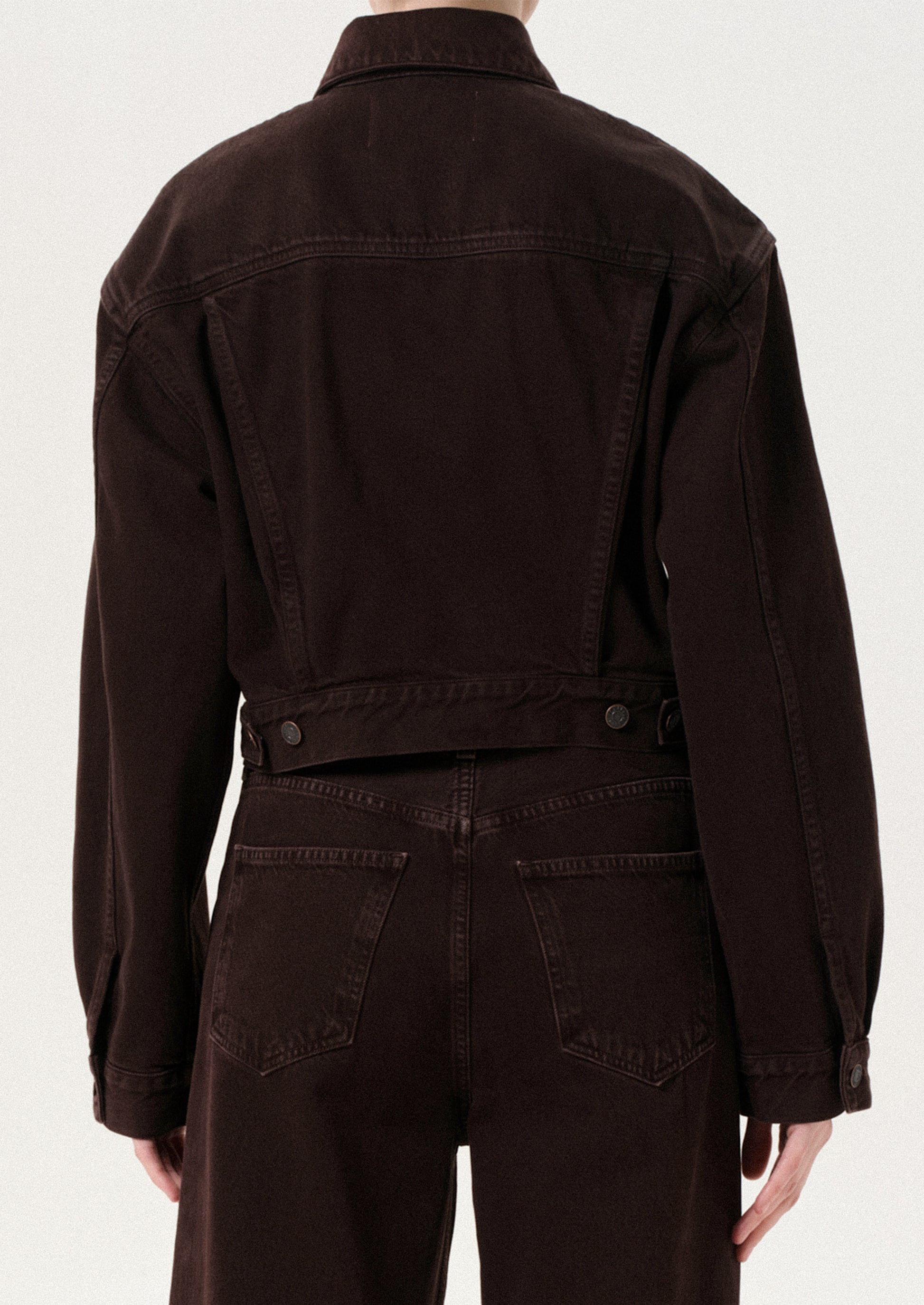 Brown jacket and pants worn by a person on a white background