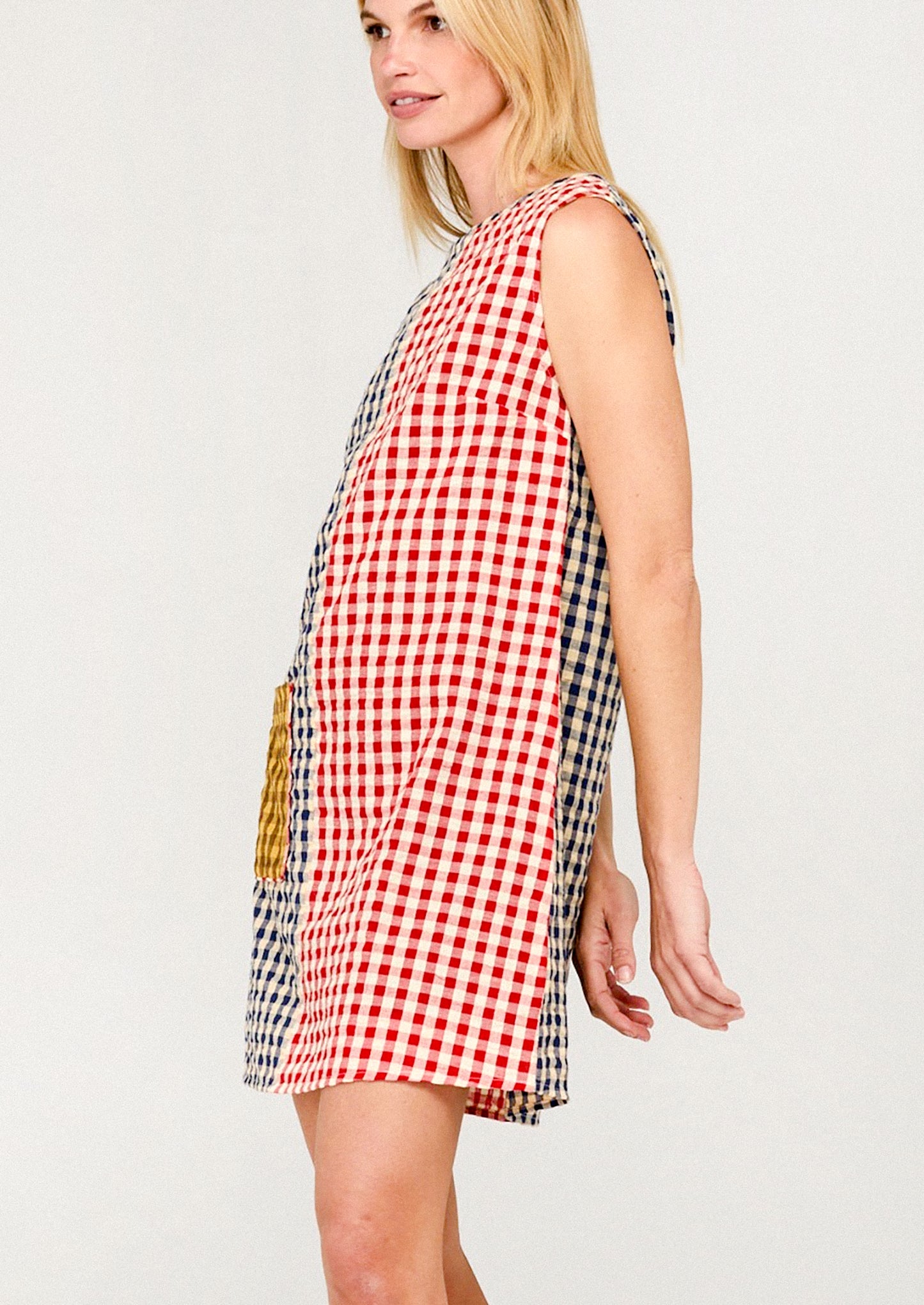 Woman wearing a red and white checkered dress on a plain background
