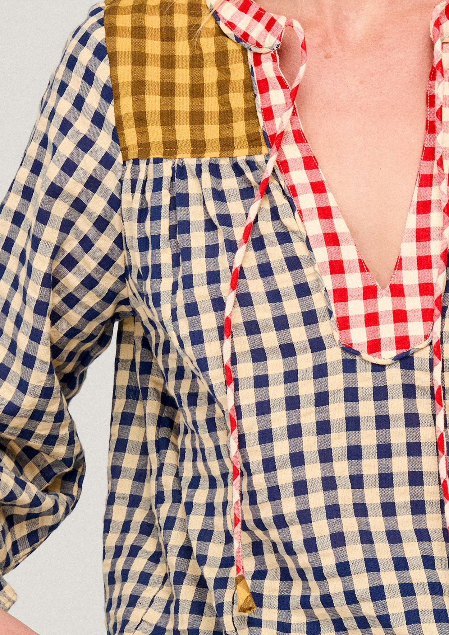Close-up of a person wearing a checkered shirt with a red and white patterned collar.
