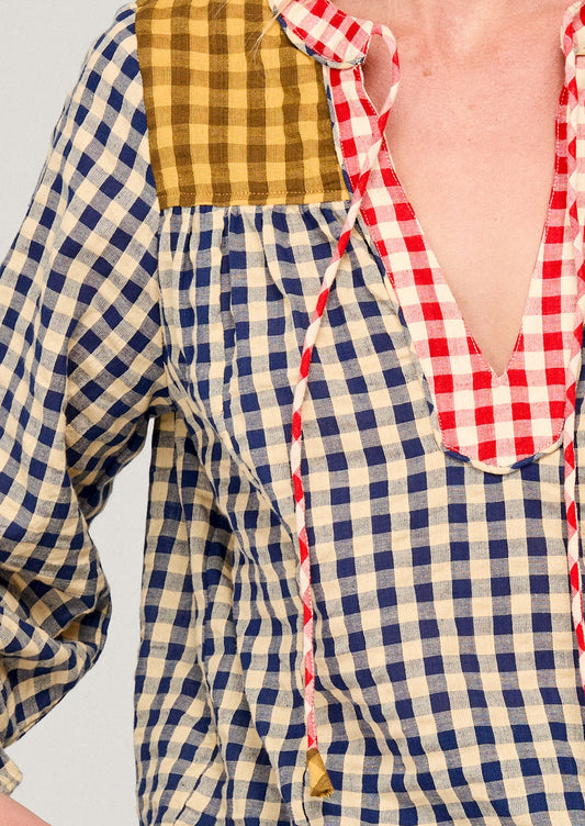Close-up of a person wearing a checkered shirt with a red and white patterned collar.