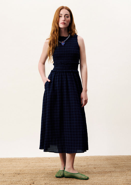 Woman wearing a checkered dress on a white background