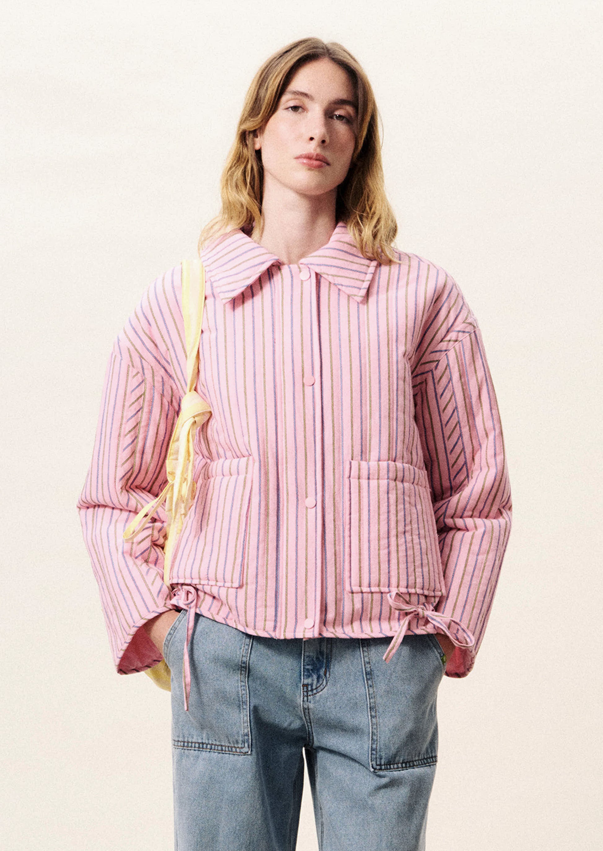 Person wearing a pink striped jacket with a white background