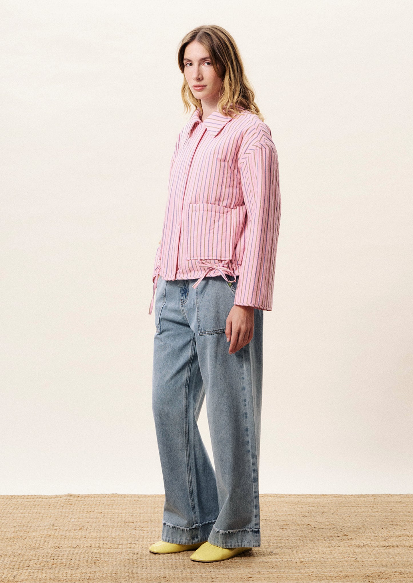 Person wearing a pink striped jacket with a white background