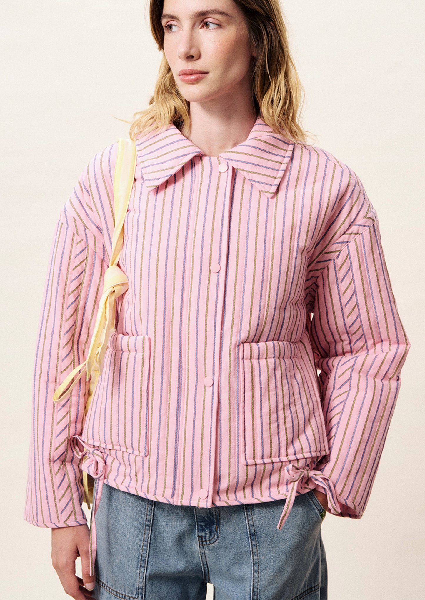 Person wearing a pink striped jacket with a white background