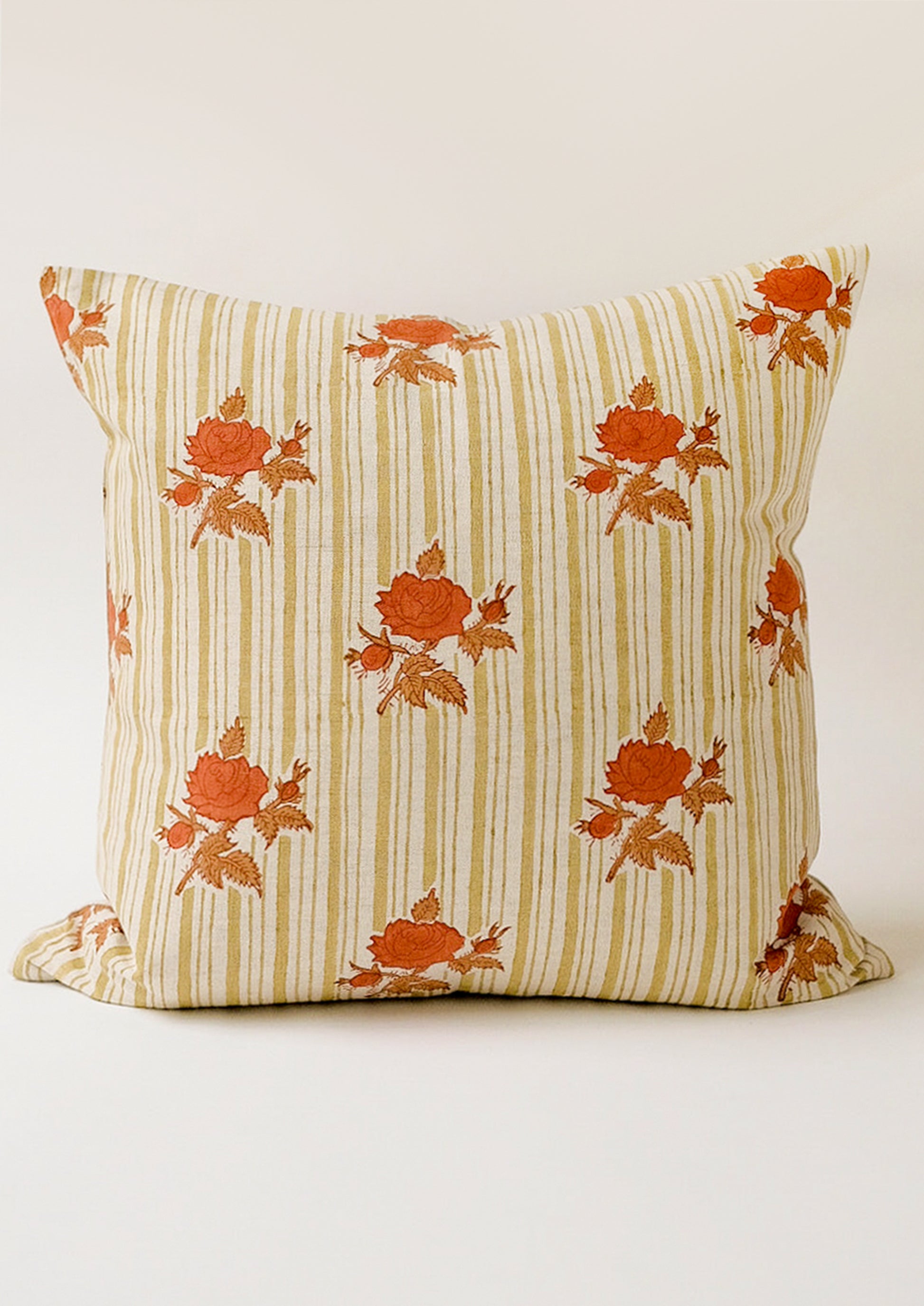 A pillow with green vertical stripes and orange floral pattern.