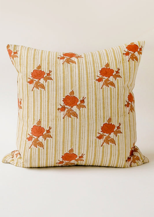 A pillow with green vertical stripes and orange floral pattern.