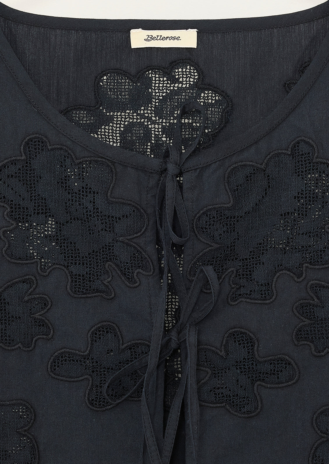 A sleeveless tie front top in black with tonal lacework detailing and peplum hem.