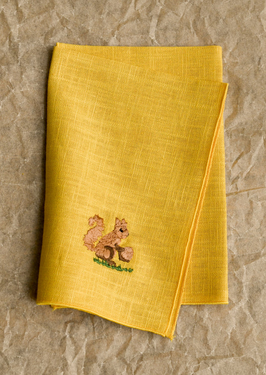 Yellow napkin with a squirrel design on a textured surface