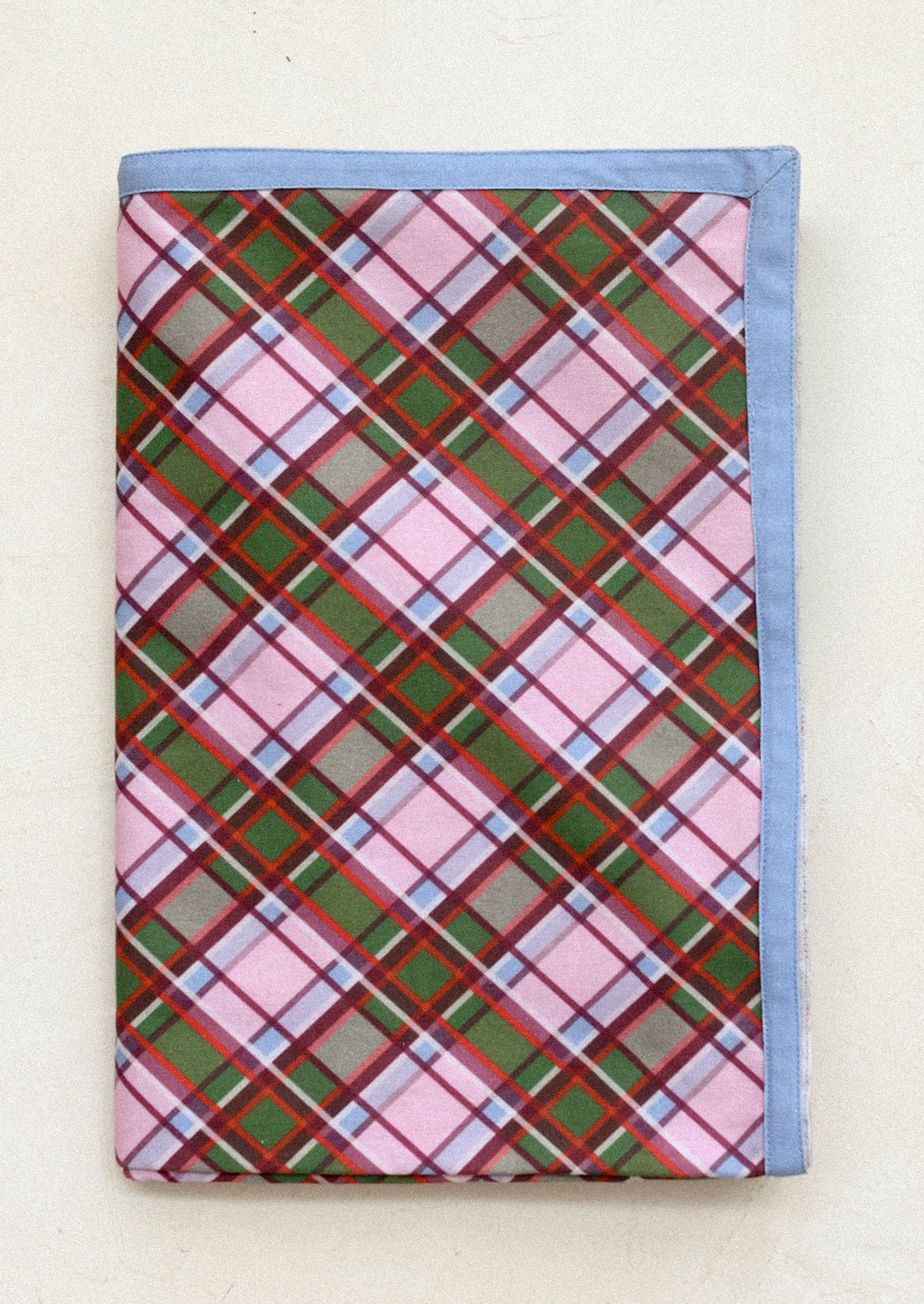 Plaid patterned fabric with pink, green, and blue colors on a white background