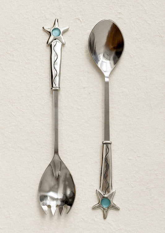 Two decorative spoons with star and turquoise stone designs on a light background