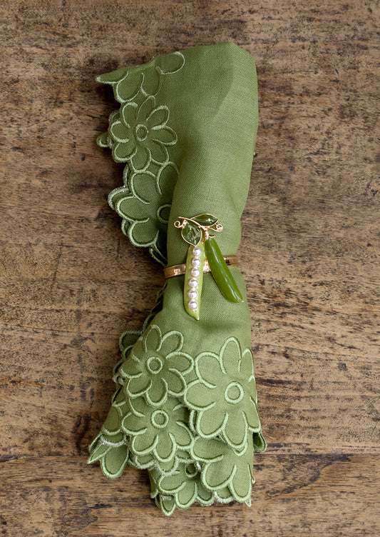 Green napkin with decorative ring on a wooden surface