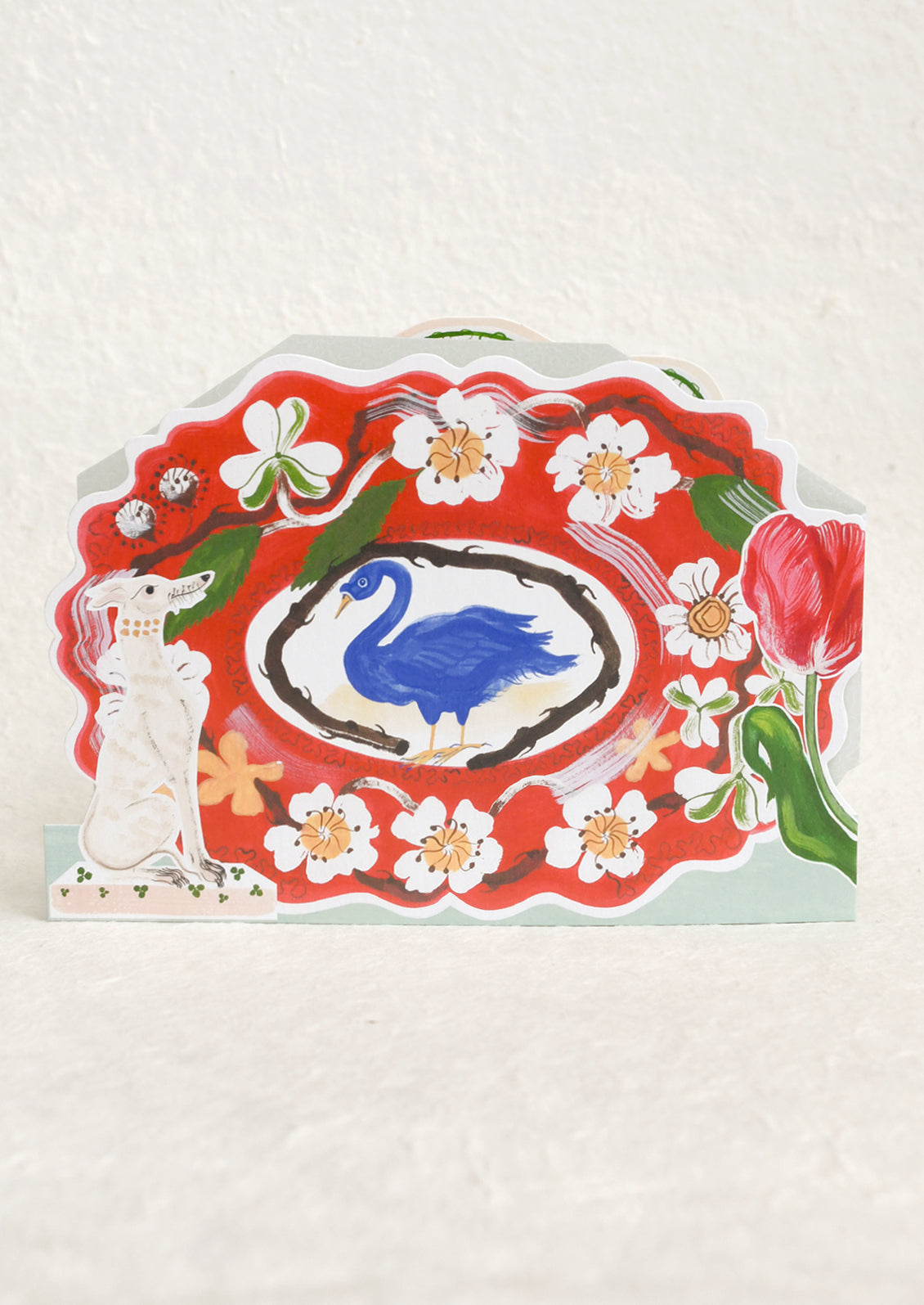 Decorative card with a blue duck illustration on a red background with floral elements.