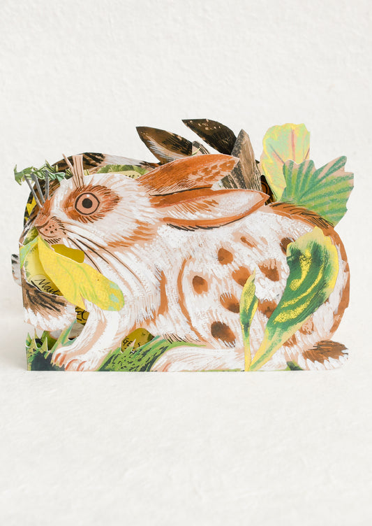 Card with a rabbit illustration surrounded by leaves on a white background