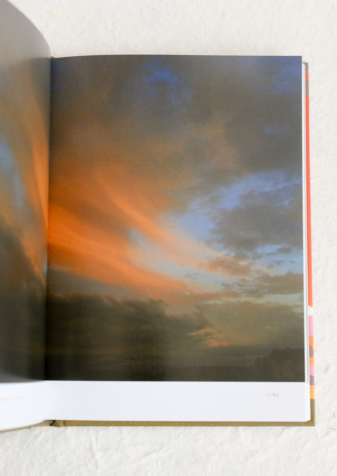 Open book showing a painting of a sunset landscape