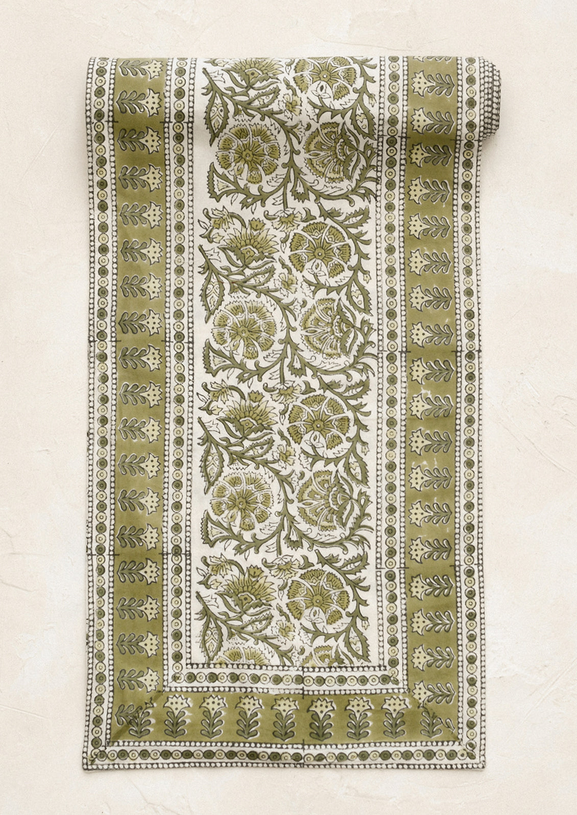 Decorative green and white patterned fabric roll on a beige background