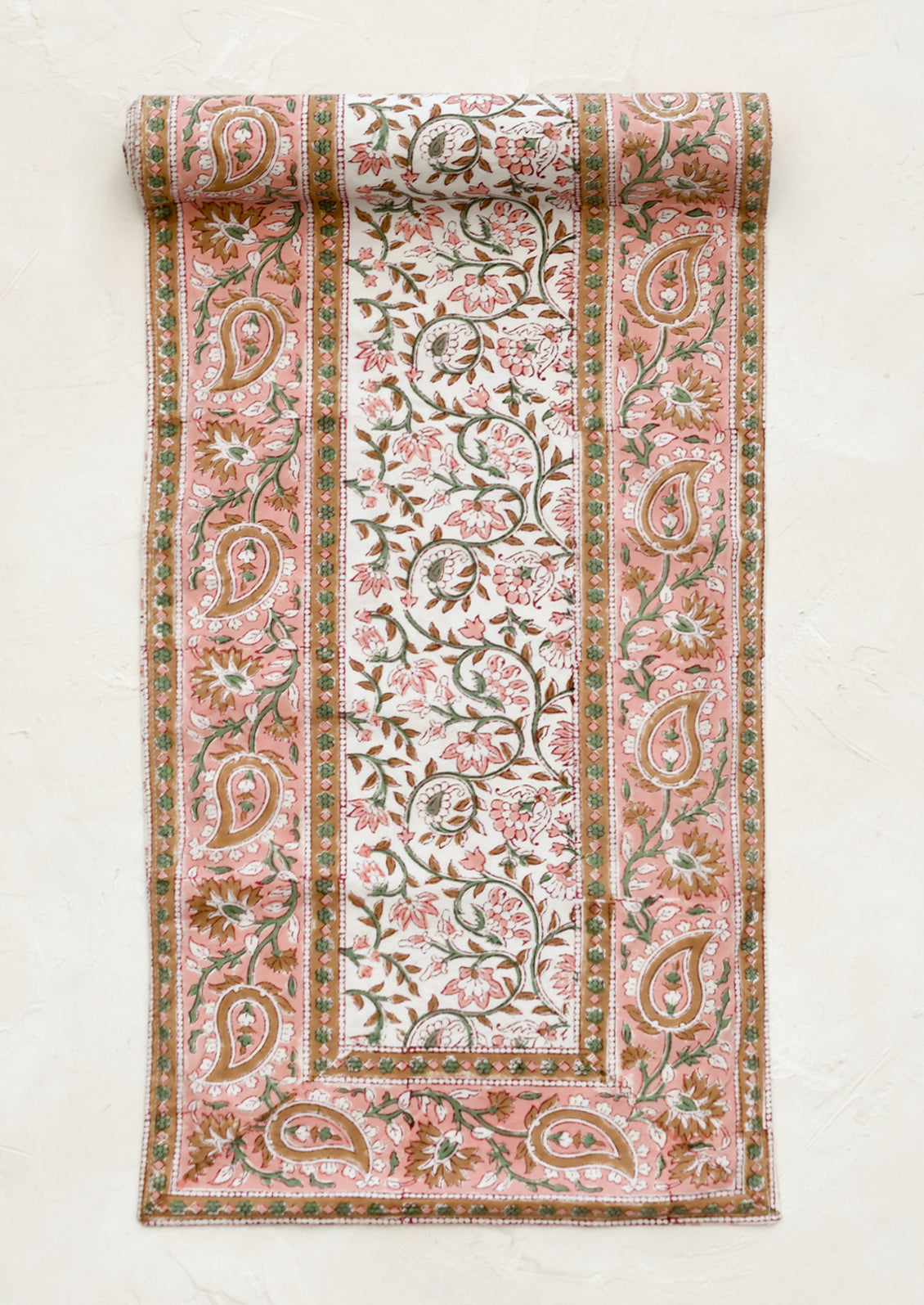 Floral and paisley patterned fabric roll on a white background