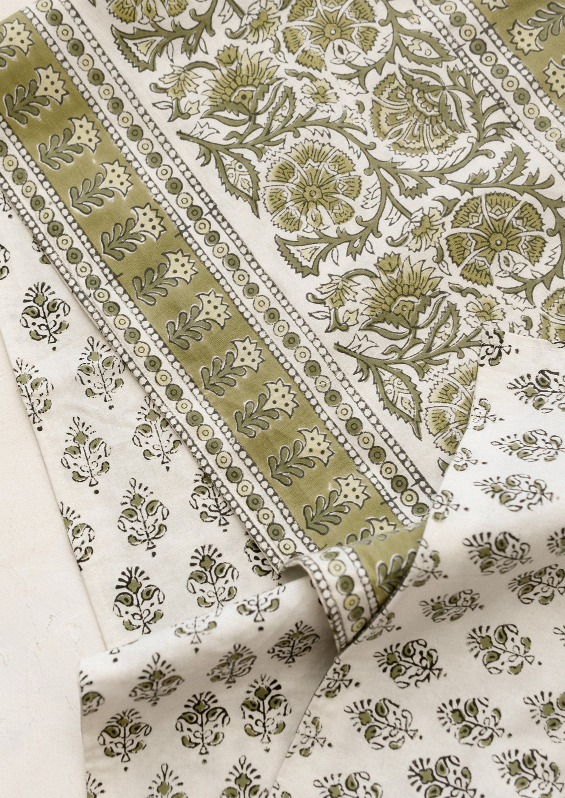 Green and white patterned fabric with floral designs