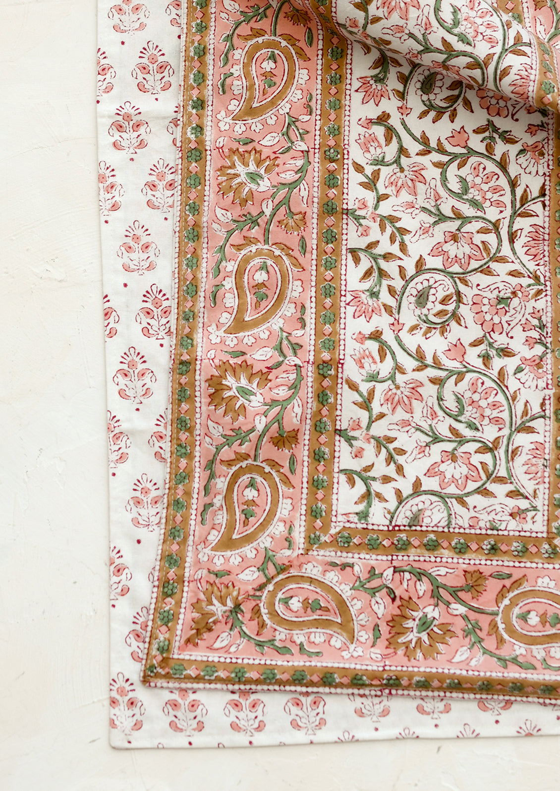 Close-up of a floral and paisley patterned fabric on a white background
