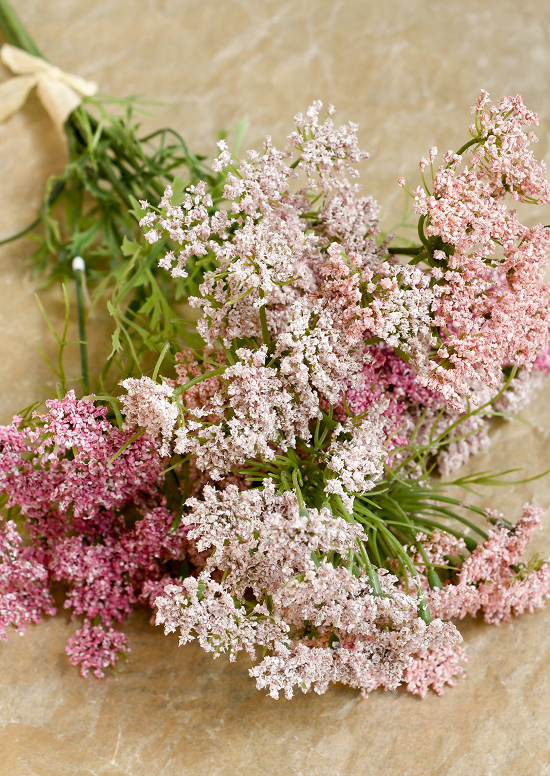 Bouquet of pink and white flowers on a textured beige background