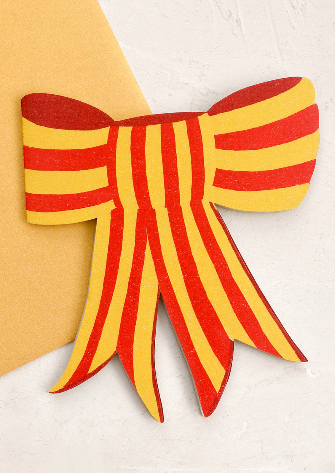 A diecut card in the shape of a bow.