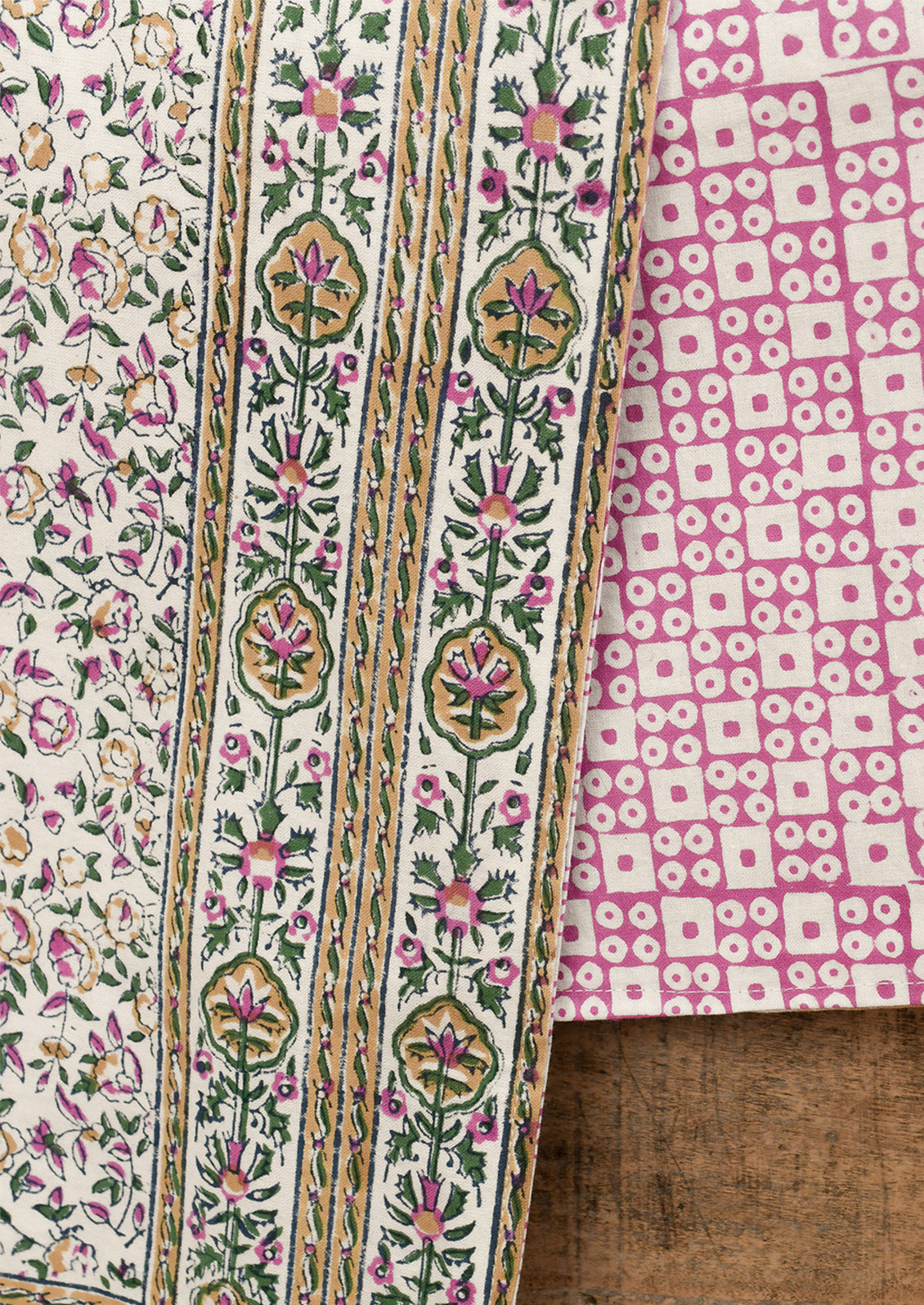 Two pieces of fabric with intricate patterns on a wooden surface