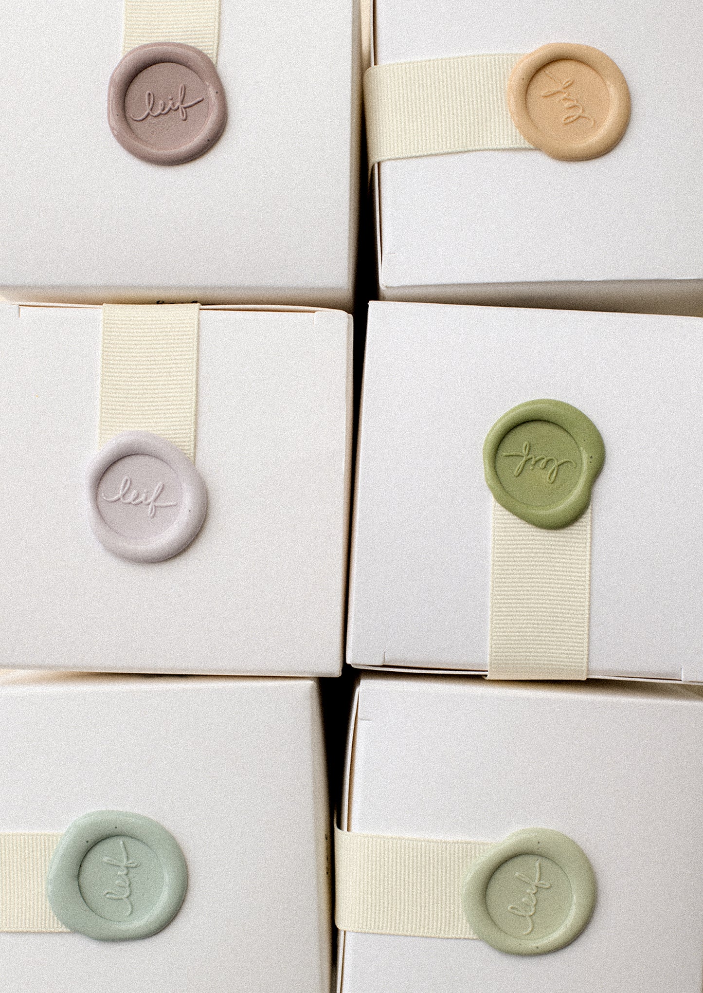 Colorful wax seals on candle boxes.