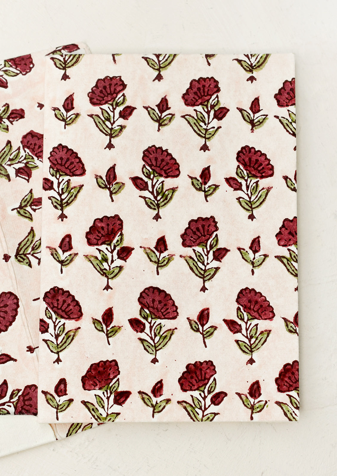 A block printed floral card with matching lined envelope in red and pink colorway.