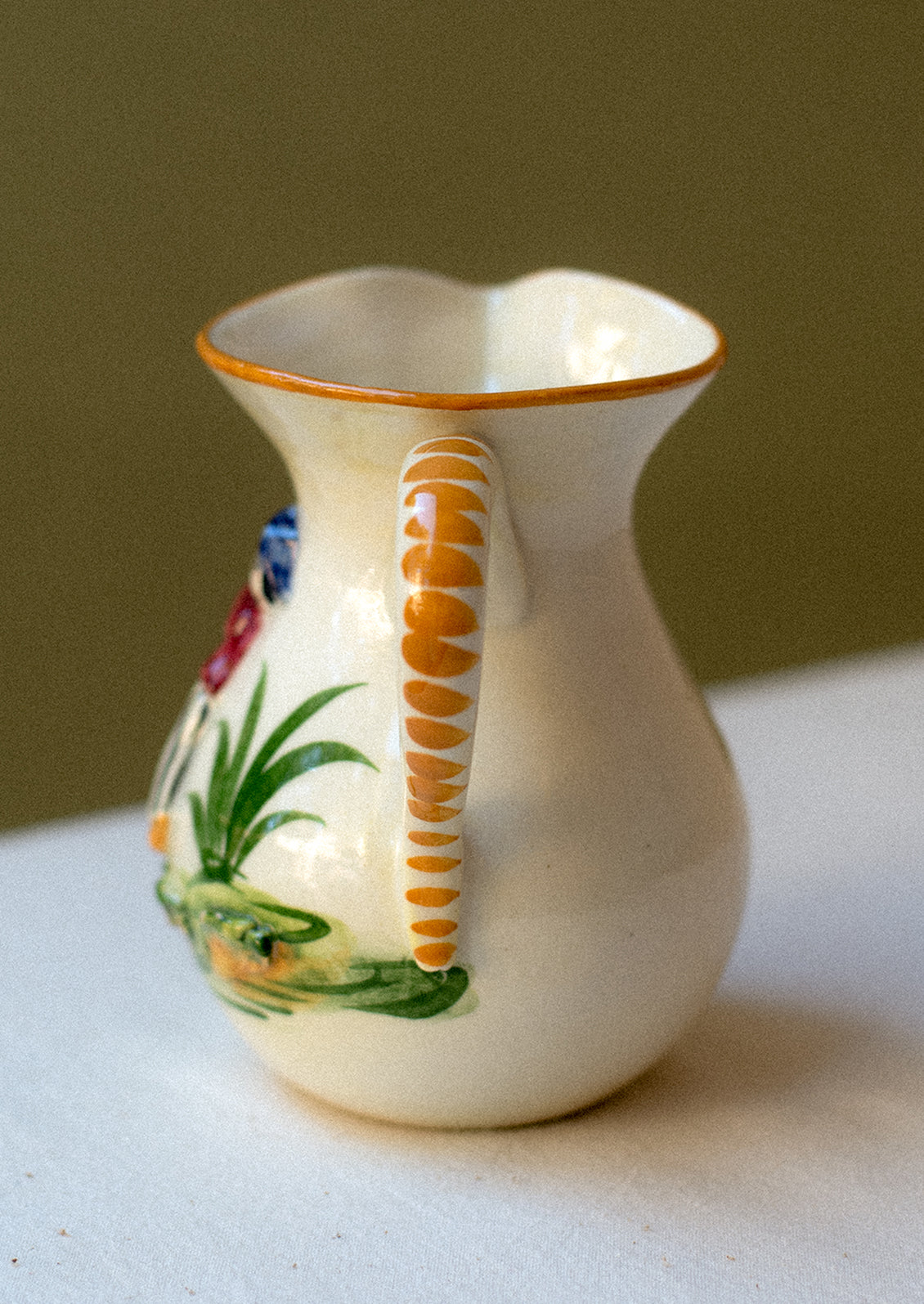 Vintage hand-painted porcelain mini pitcher / creamer with three-dimensional relief detail.