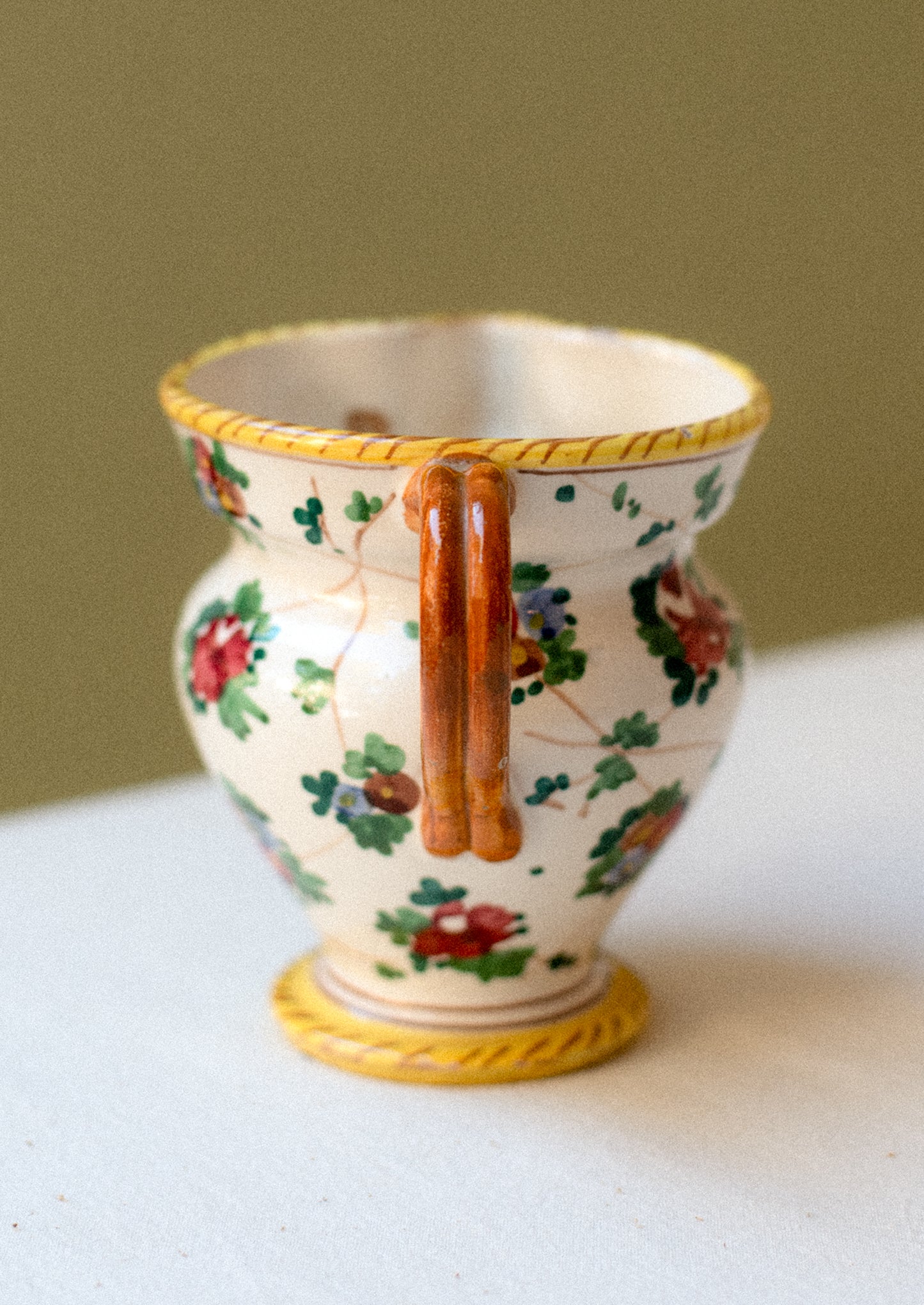 A painted porcelain pitcher with floral pattern.