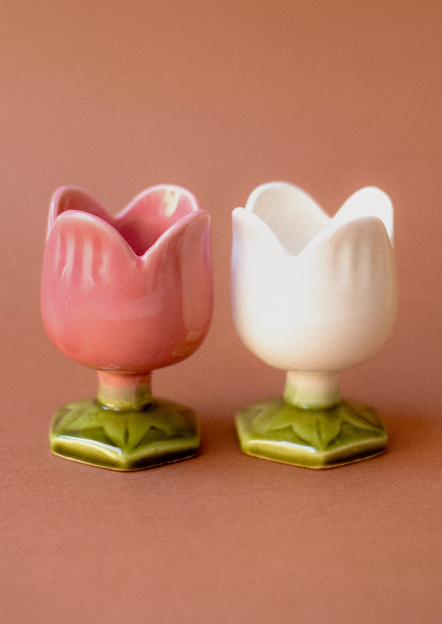 A pair of tulip egg cups in pink and white.
