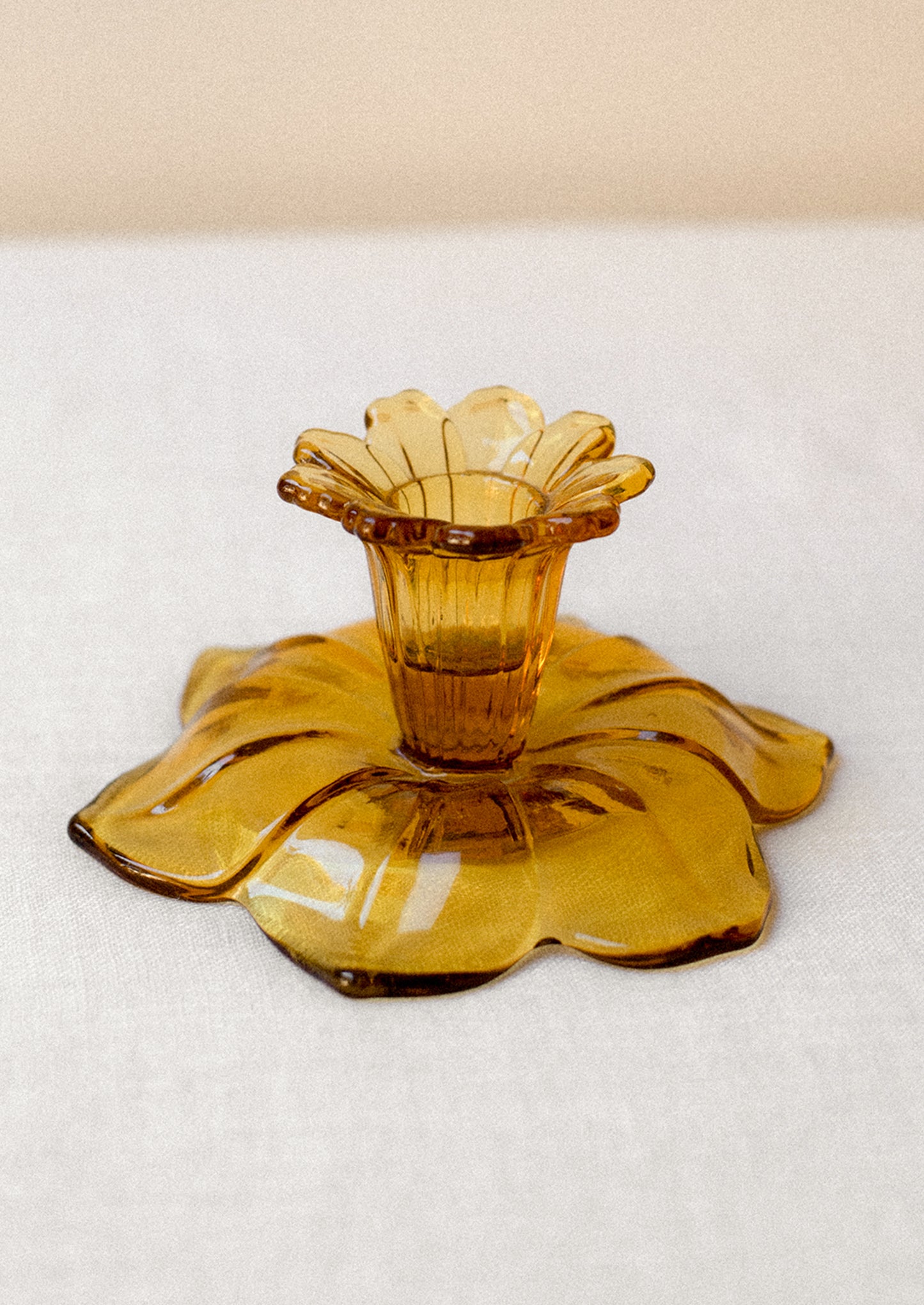 A pair of amber glass candle holders in the shape of daffodils.