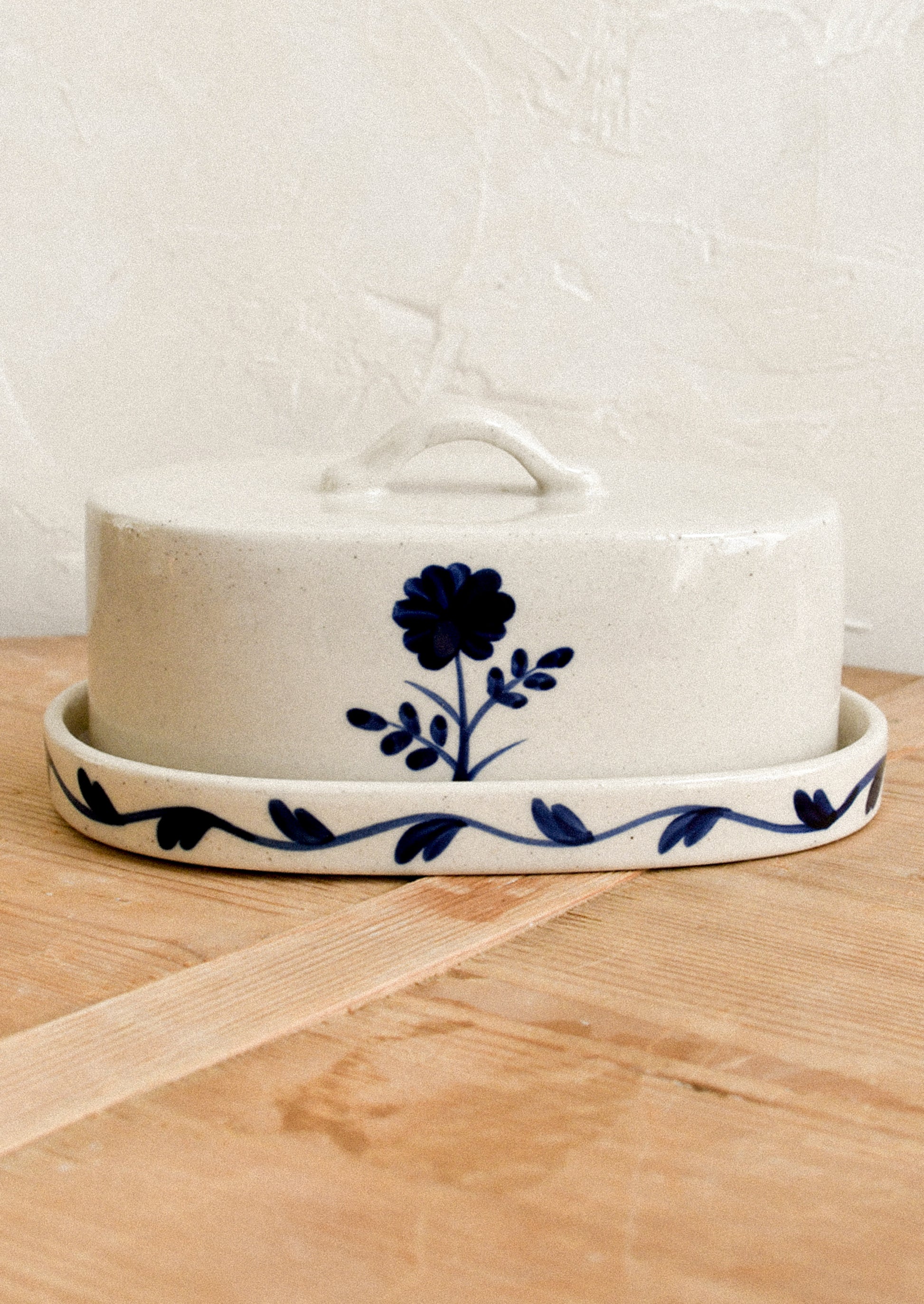 A lidded butter dish with blue flower pattern.