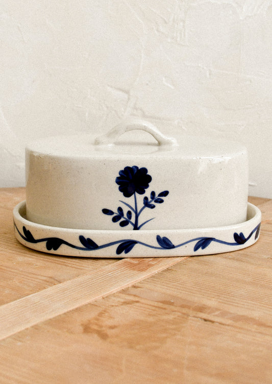 A lidded butter dish with blue flower pattern.