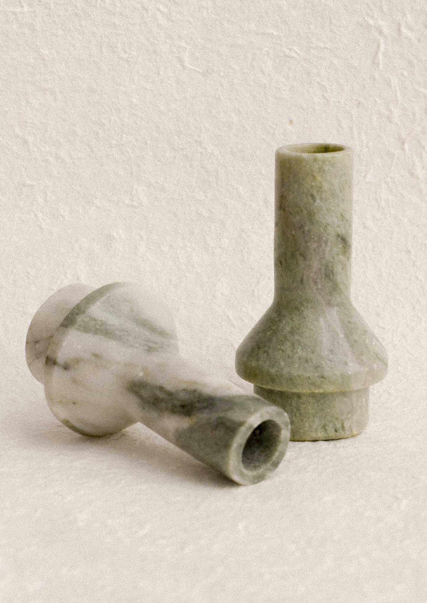 A sculptural candle holder in variegated green marble.