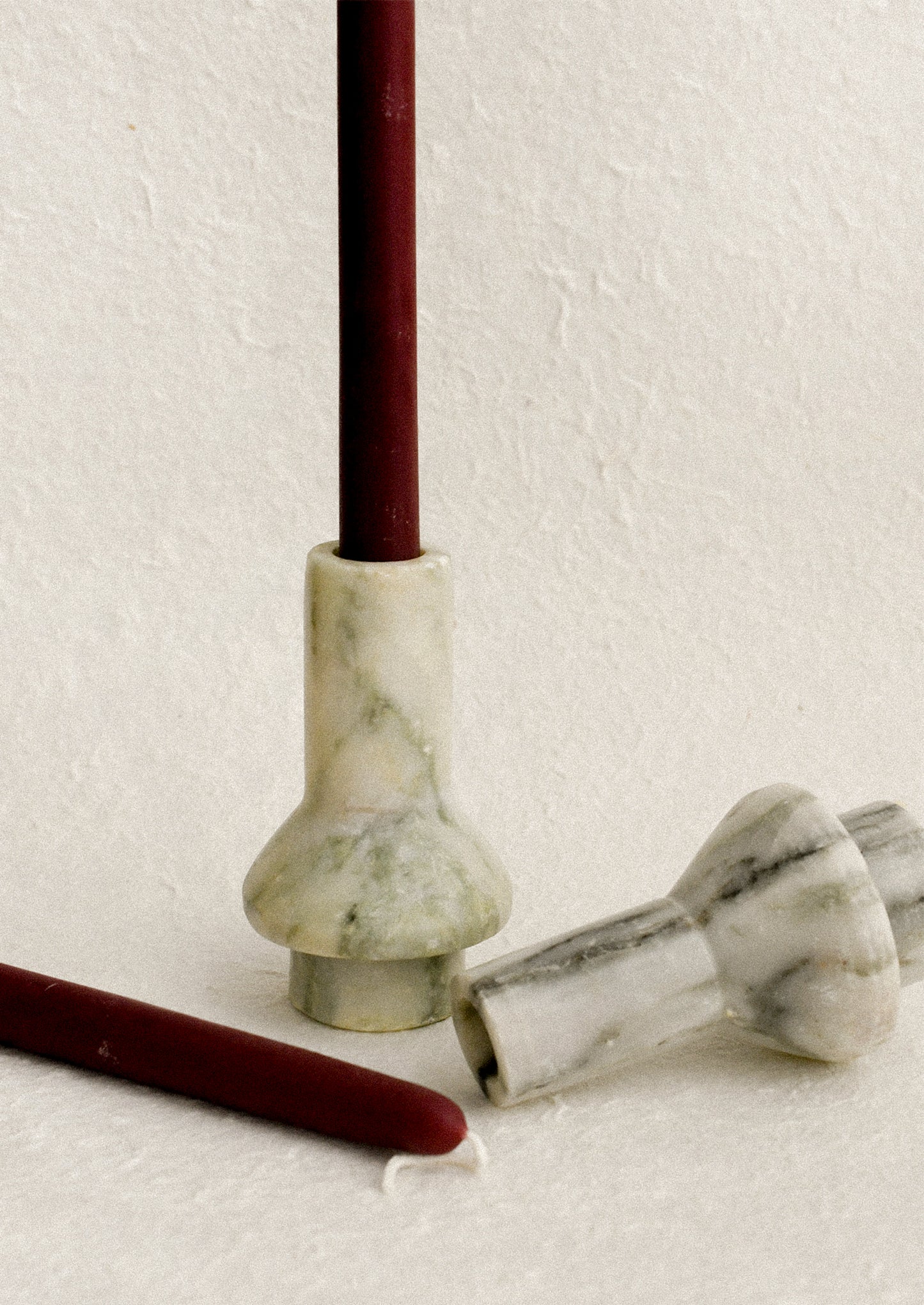 A sculptural candle holder in variegated green marble.