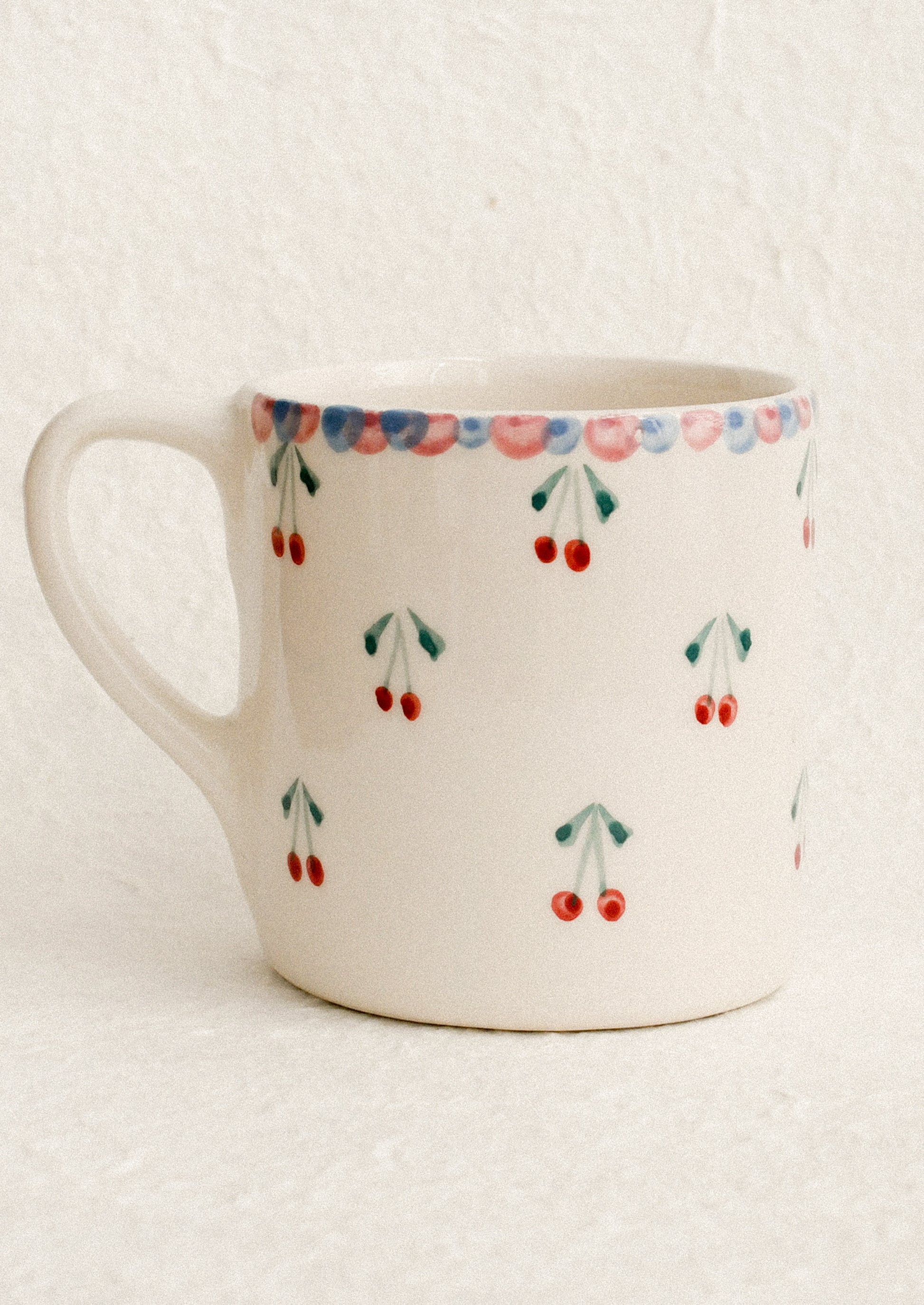 A hand painted mug with cherries motif.