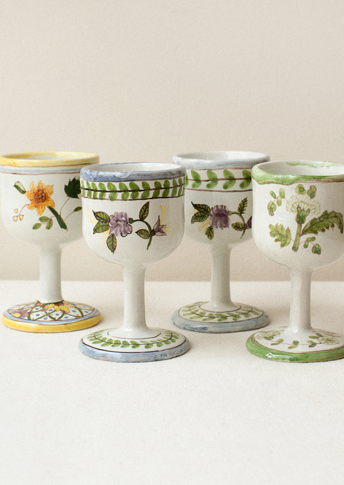 A set of four floral painted wine glasses.
