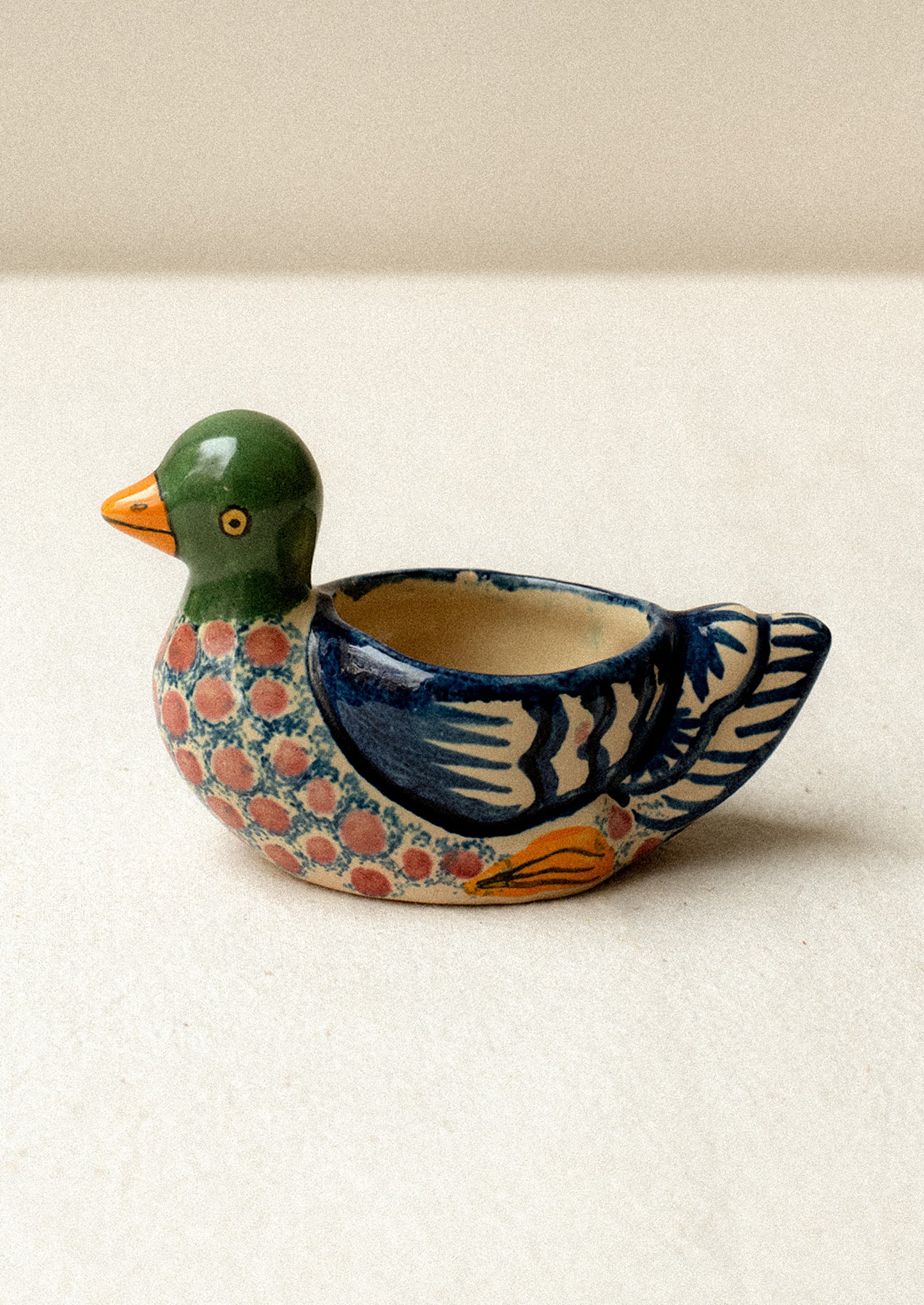 A hand-painted egg cup in the shape of a duck.