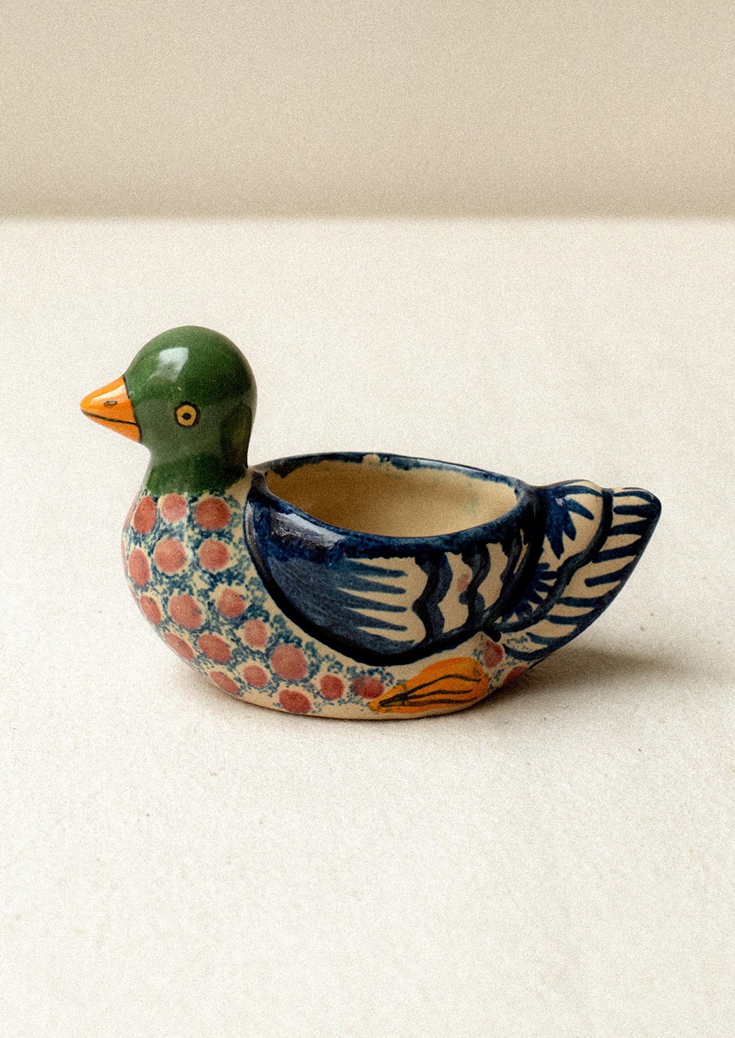 A hand-painted egg cup in the shape of a duck.