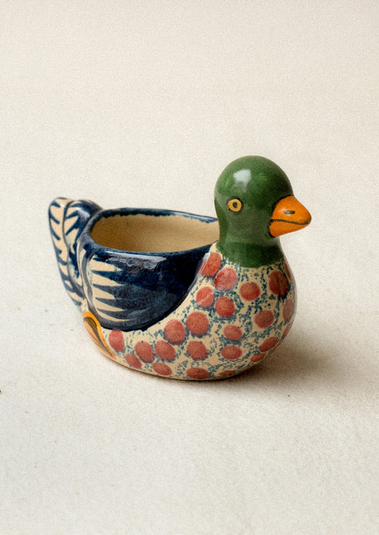 A hand-painted egg cup in the shape of a duck.