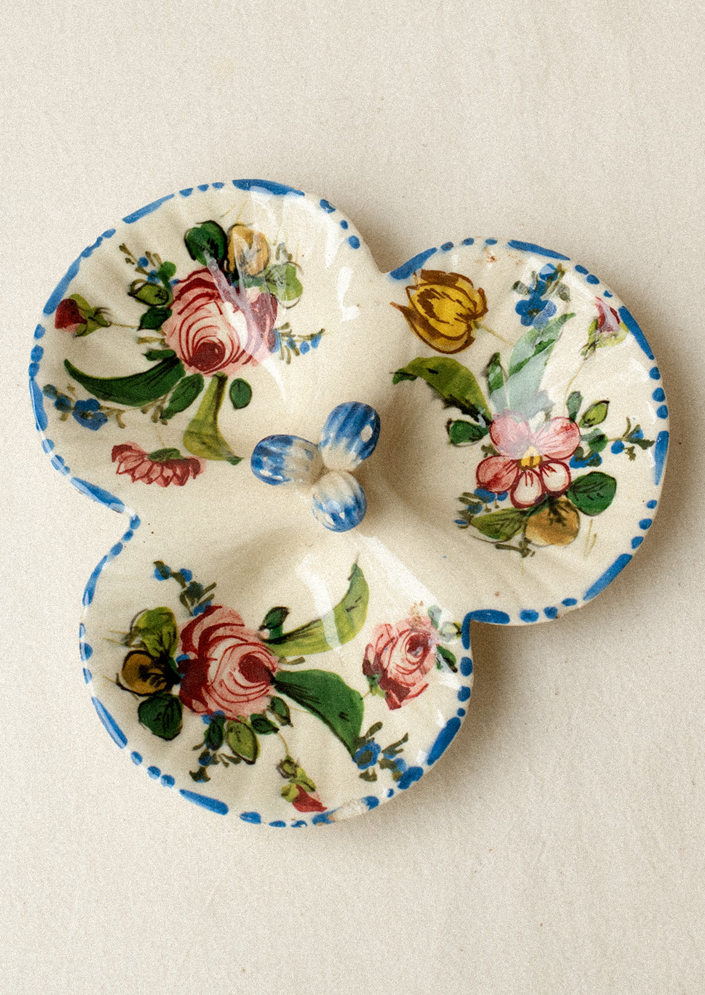 A triple well ceramic dish with hand painted floral pattern.