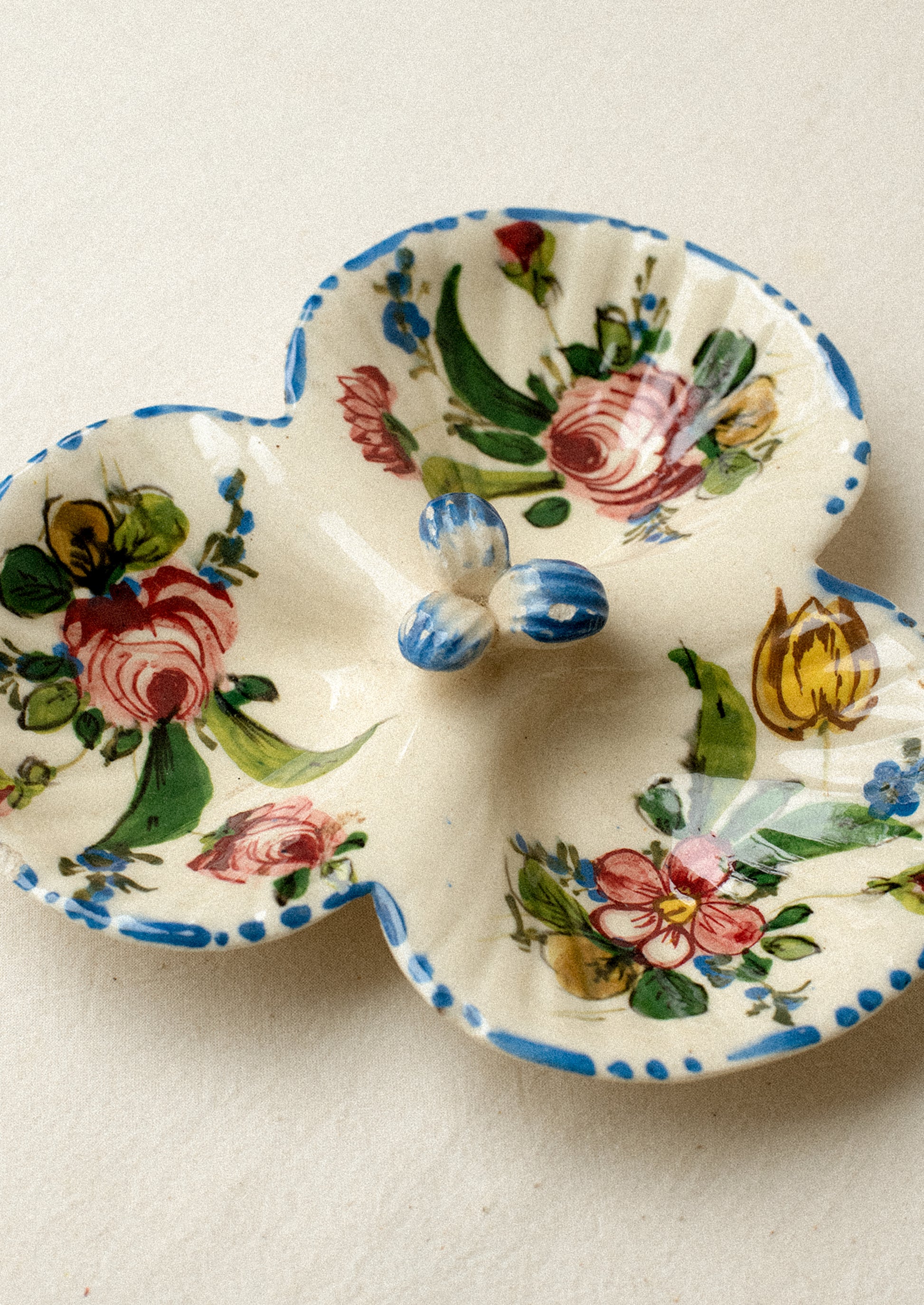 A triple well ceramic dish with hand painted floral pattern.